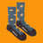 Men’s blue heathered merino wool socks with yellow beaver and brown log pattern and dark gray reinforced toe and heel