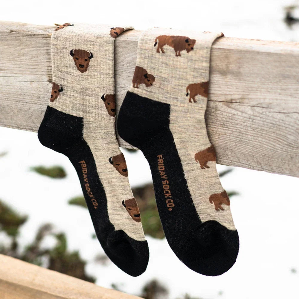 A pair of beige merino wool socks with brown bison prints black toe and heel by friday sock co for hiking