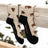 A pair of beige merino wool socks with brown bison prints black toe and heel by friday sock co for hiking