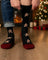 Men’s gingerbread bite merino wool socks in black with festive gingerbread pattern and maroon heel and toe accents