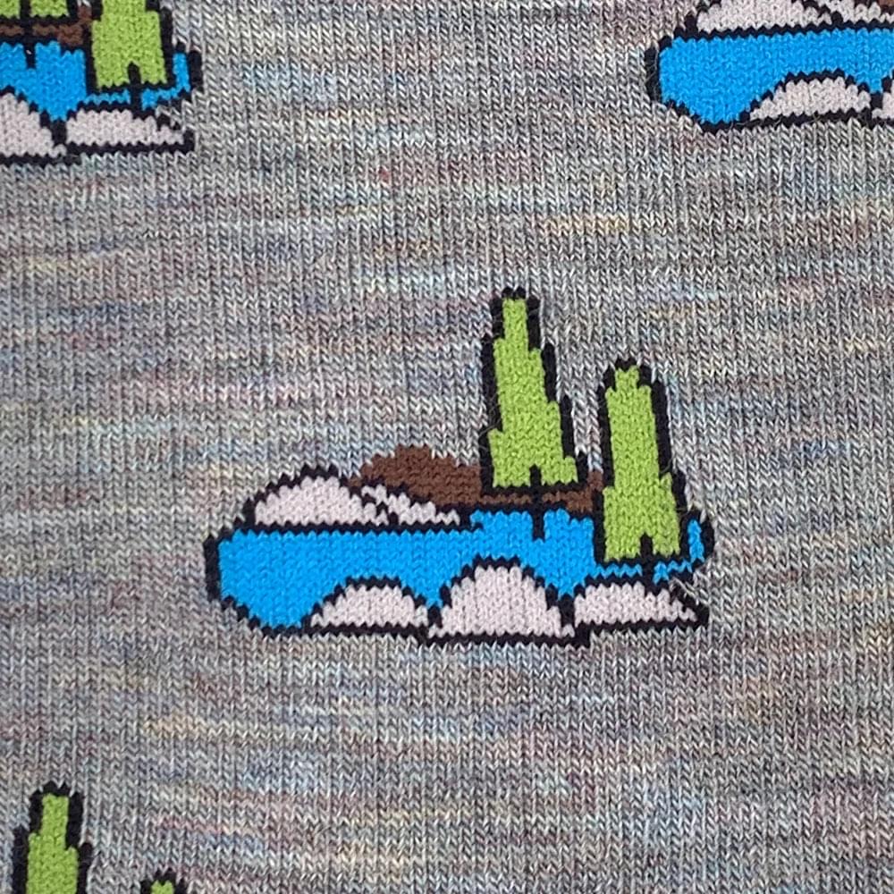 Gray knit merino wool socks with pixelated green trees island design perfect for all season outdoor wear