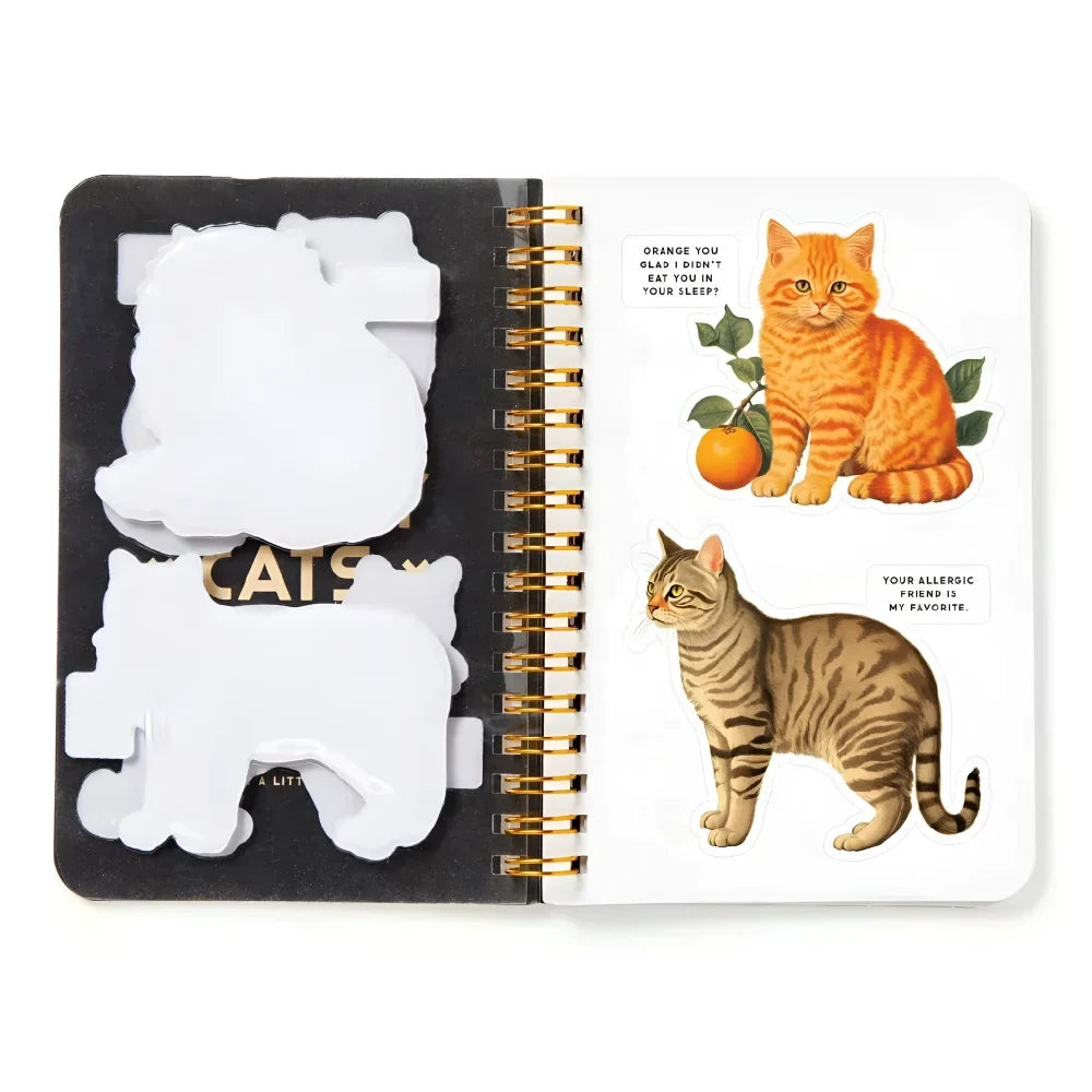 White cat-shaped sticky notes in black case next to open moody cats sticker book with illustrated cats pages