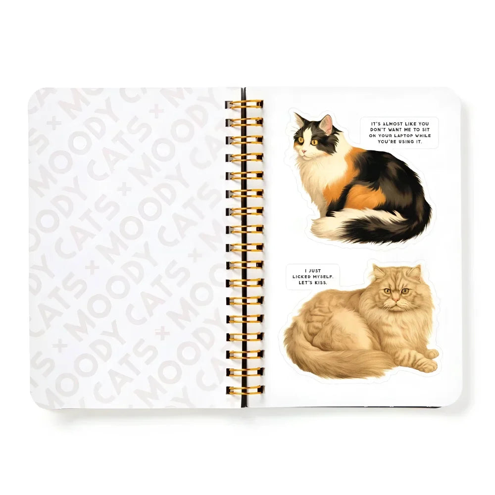 A white spiral-bound sticker book with gold rings featuring illustrated cats sticker designs from moody cats sticker book