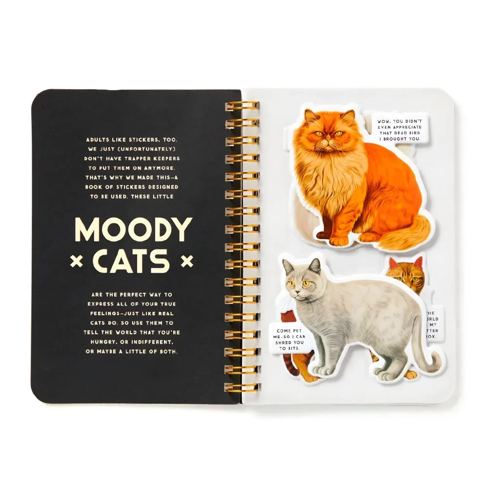 A black spiral-bound cats sticker book titled moody cats sticker book with colorful cat stickers on the right page