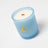 A light blue frosted glass coconut soy candle jar with gold moon and sun logo and creamy white wax wooden wick