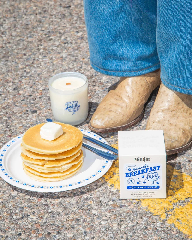 Stack of golden pancakes with butter on a white plate featured on an 8oz soy candle labeled pancake breakfast butter syrup and blueberry