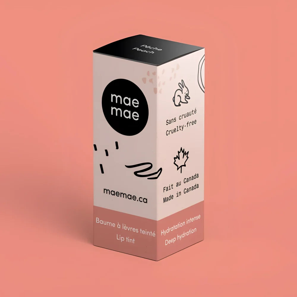 A peach natural lip tint in minimalist cardboard packaging with black and pink accents from mae mae