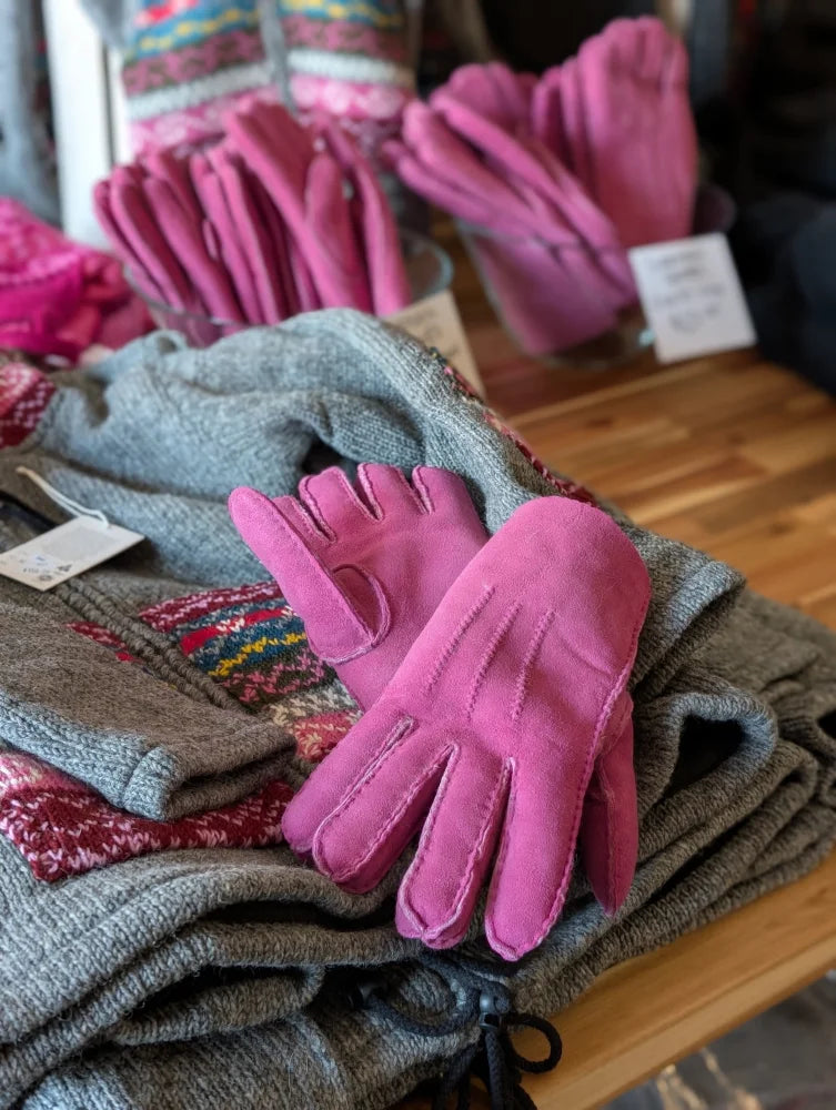 Ten pairs of brilliant shade pink sheepskin gloves with black drawstring