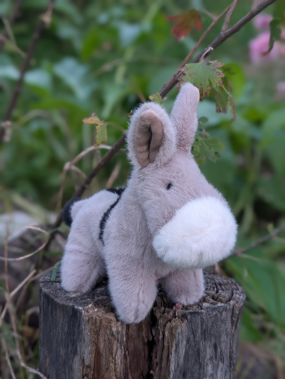 A plush gray and black cow toy called the donkey with a soft fuzzy texture perfect for cuddling