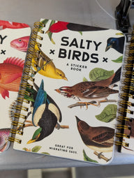 A spiral-bound white cover birds sticker book titled salty x birds with colorful shady birds illustrations