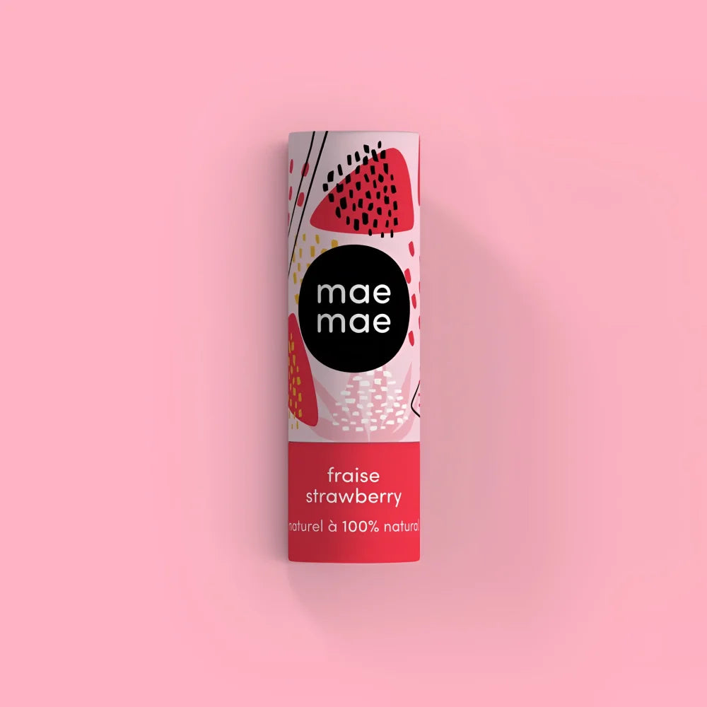 A cylindrical tube of mae mae strawberry natural lip balm with a white and red label featuring illustrated strawberries lip balms