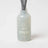 A translucent gray frosted glass milkjar reed diffuser with an etched logo for sunnyside pear and nectarine diffuser smells