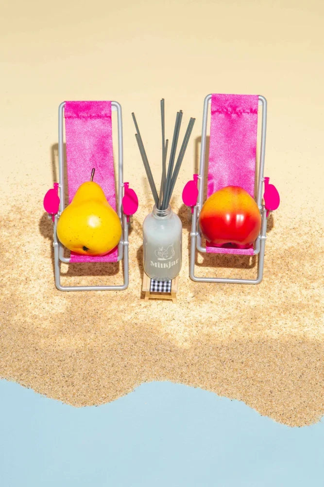 A sleek frosted glass sunnyside pear and nectarine reed diffuser with dark sticks offering fresh diffuser smells
