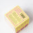 Yellow cardboard box with purple floral patterns showing safety instructions for sunsyside pear and nectarine coconut soy candle smells