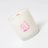 A frosted white glass coconut soy candle with a pink hugging pears design and sunnyside branding that candle smells fresh