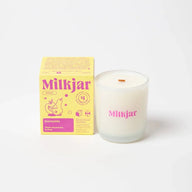 A white sunnyside pear and nectarine coconut soy candle with a wooden wick in a clear glass jar with pink branding smells great