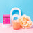 A peach-colored milkjar coconut soy candle with wooden wick sits next to its matching pink box wallflower tobacco and peony