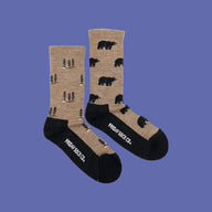 Tan women’s merino wool socks with black bear and pine tree patterns and contrasting black toe and heel
