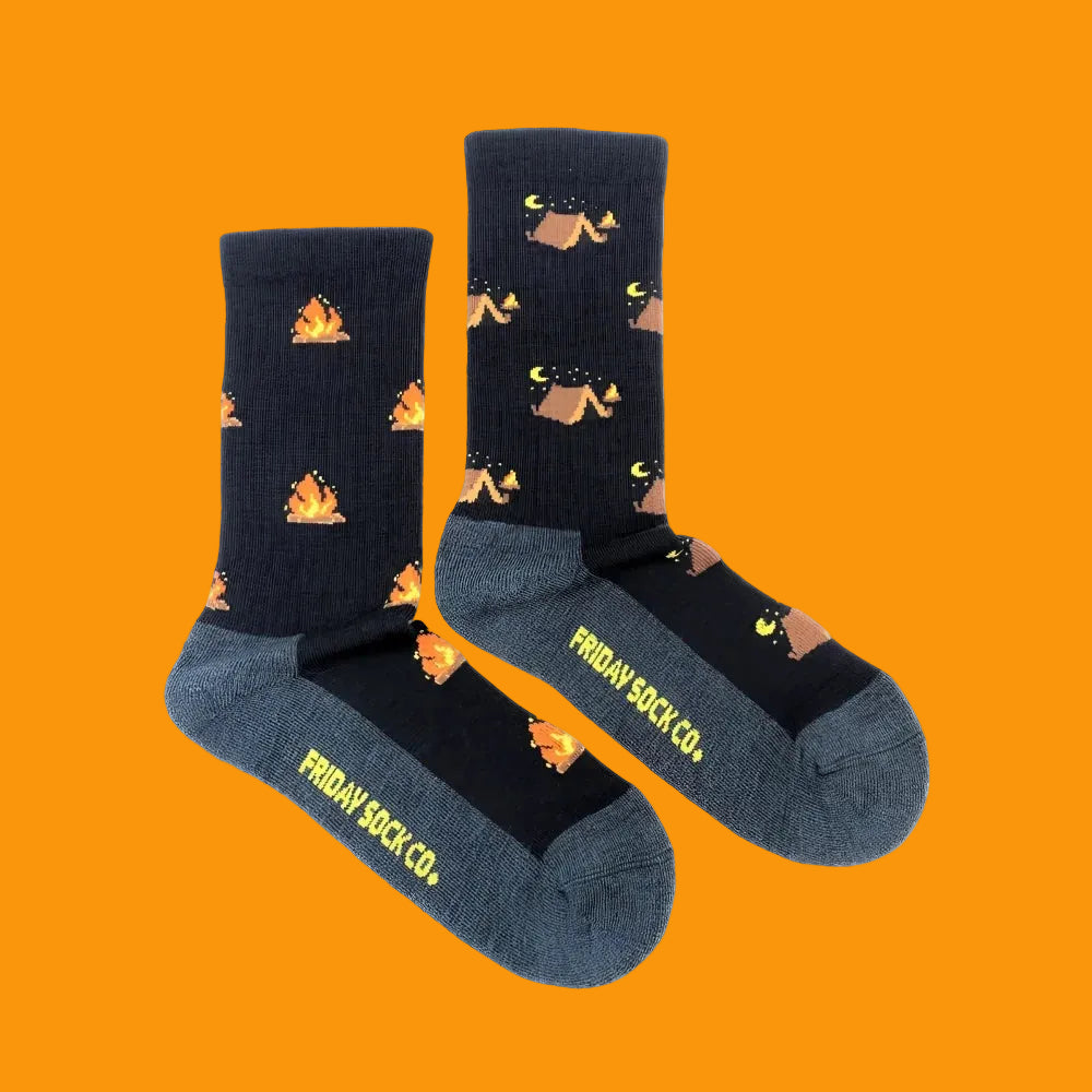 Dark blue women’s camping at night merino wool socks with orange campfires and tan tents perfect for cozy outdoor use