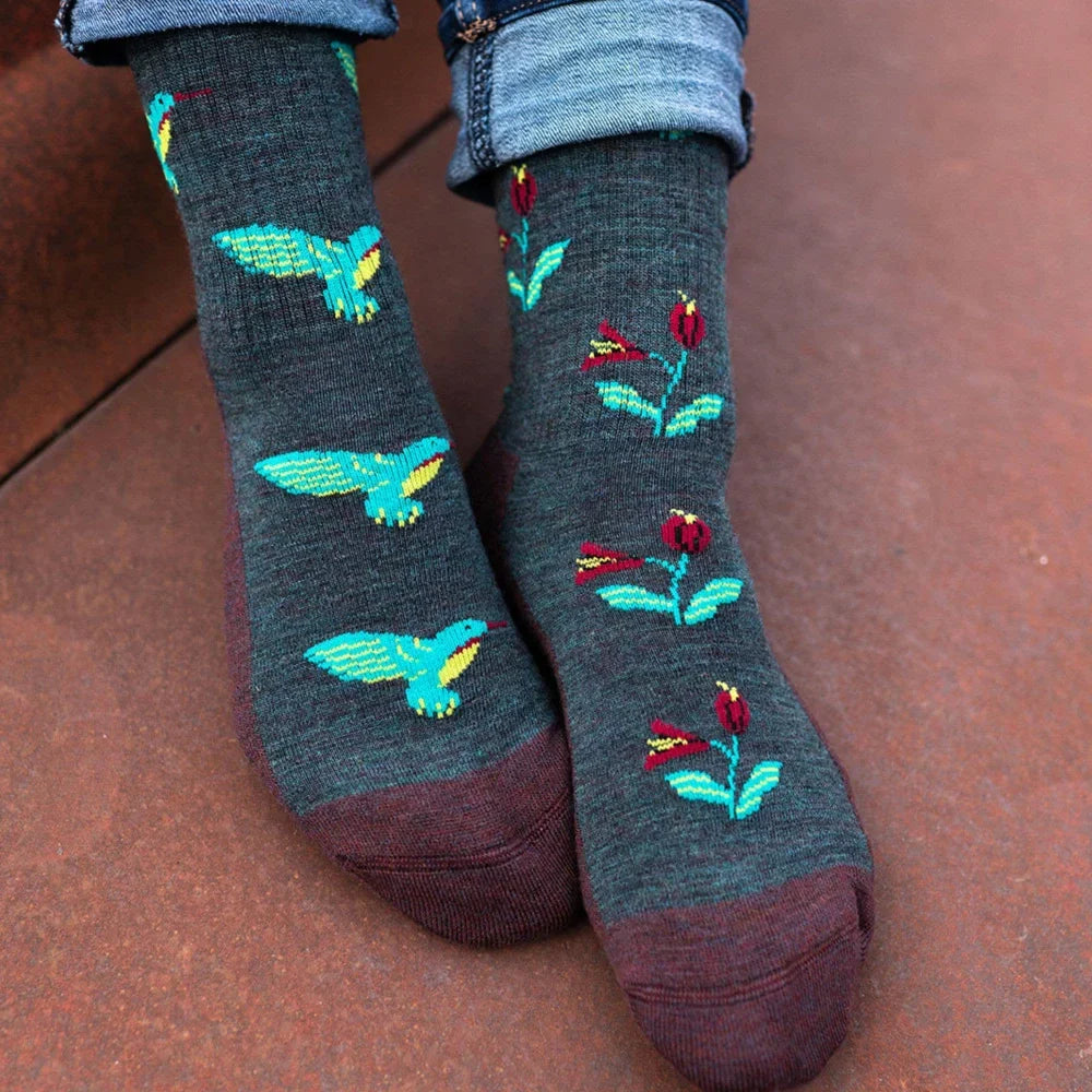 Dark gray merino wool socks with turquoise yellow hummingbirds red flowers and maroon toe caps in a fun knit pattern
