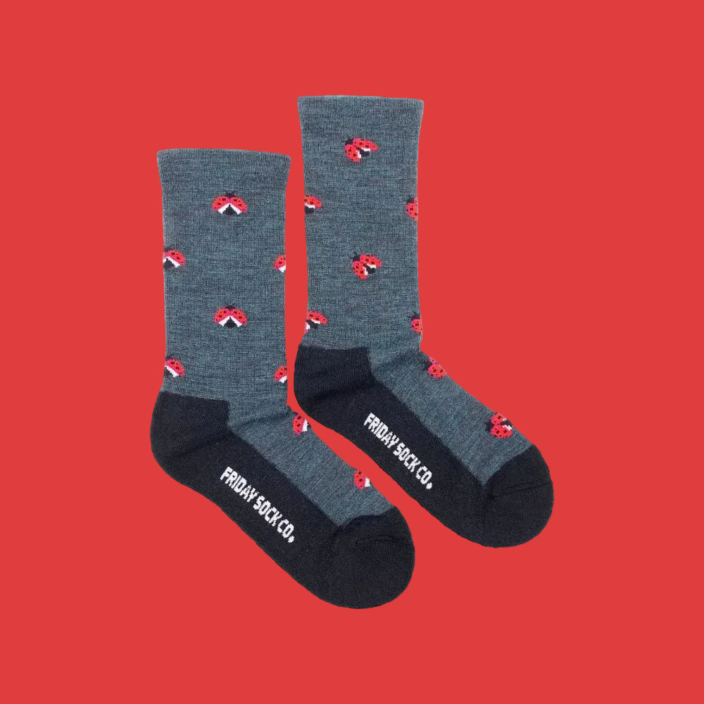 Gray women’s crew socks with red ladybug merino wool pattern and black toe caps by friday sock co