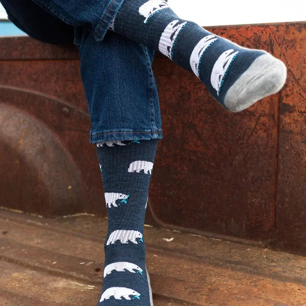 Dark blue merino wool socks with white polar bear and teal accents worn with rolled-up denim jeans for women