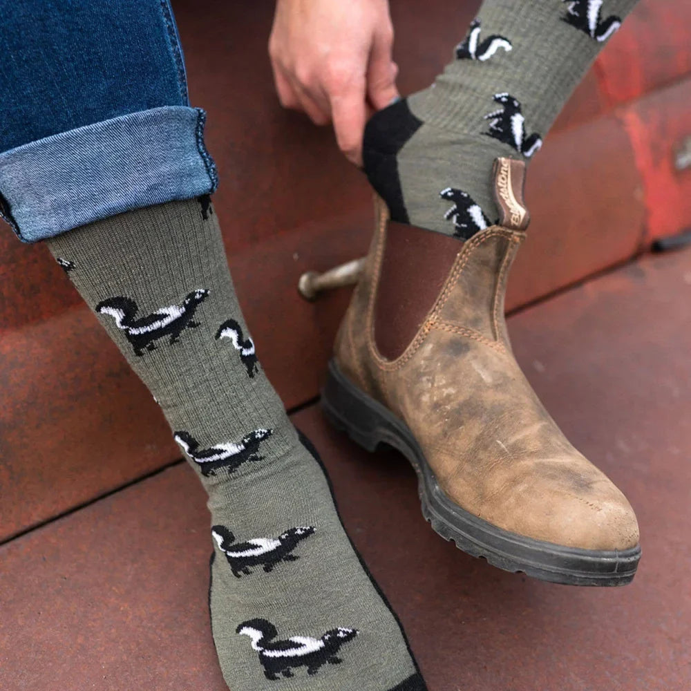 Olive green merino wool socks for women with black and white skunk pattern perfect as a mismatched gift idea