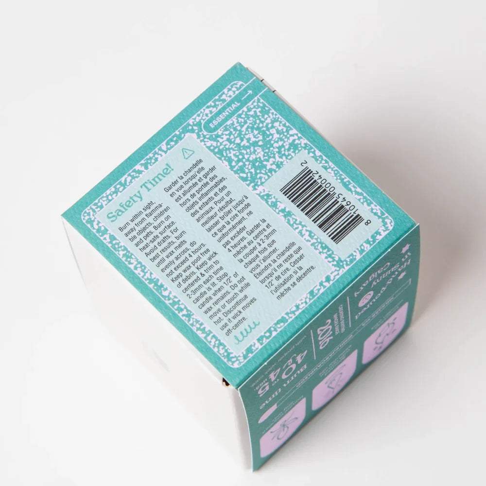 Back of teal and white patterned cardboard box for woodland essential oil coconut soy 8oz candle with barcode and instructions