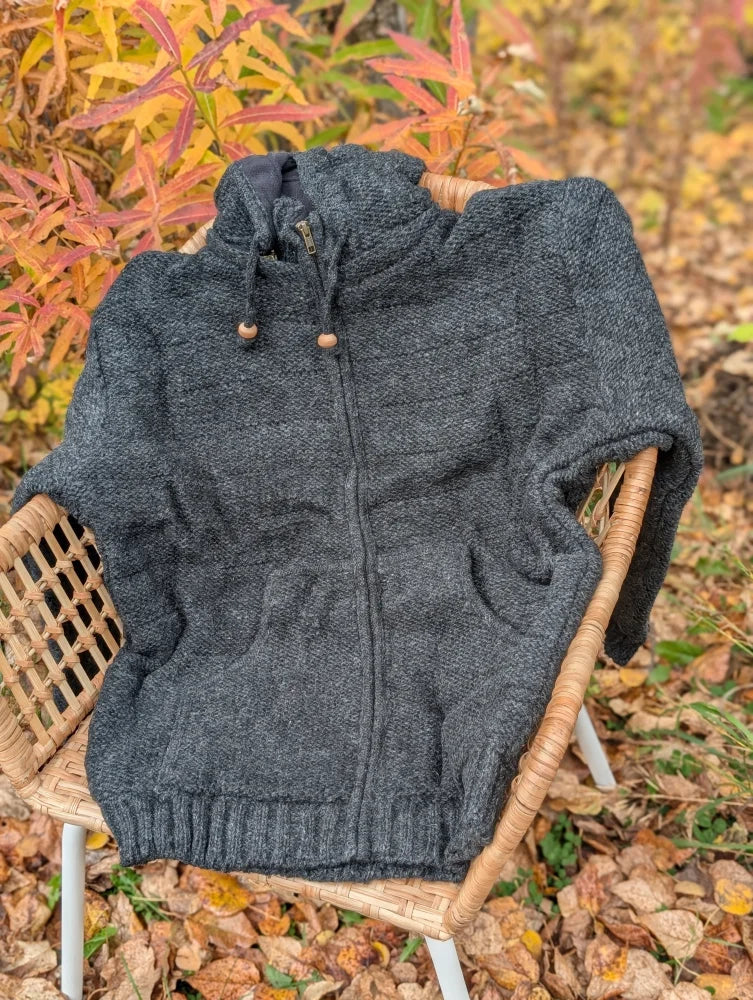 Dark gray calgary cardigan knit from zealand wool with attached hood wooden toggle drawstrings and ribbed cuffs