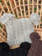 Gray woolen heelah double pompom hat with cable knit texture and fluffy double pom poms on each end