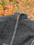 Dark gray woolen jasper vest with soft fleece lining and full-length zipper featuring leather pull tab