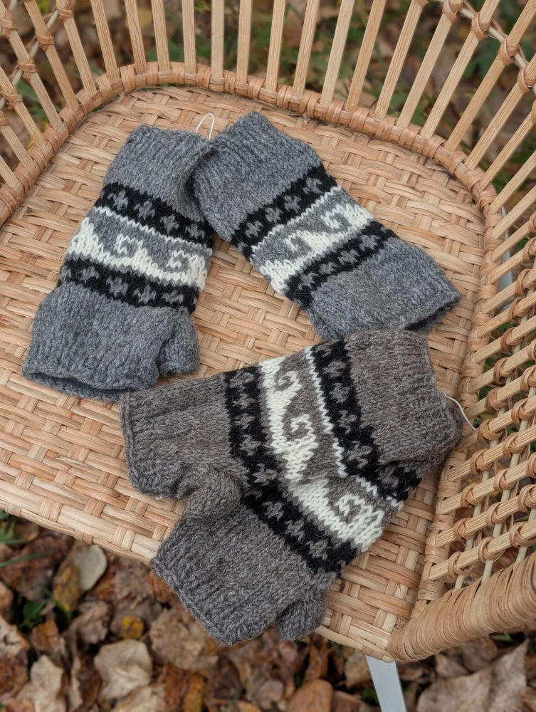 Gray knitted fingerless hand warmers with black and white geometric patterns made from fair trade zealand wool