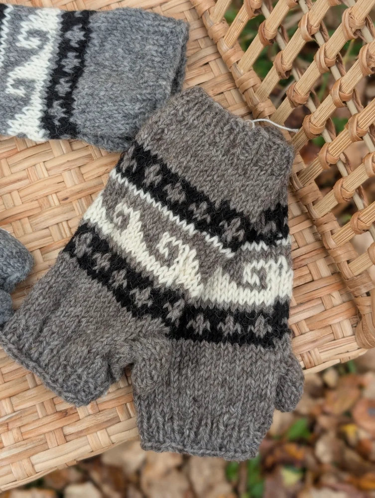 Gray knitted fingerless woolen wave hand warmers with black and cream fair trade zealand wool patterned bands